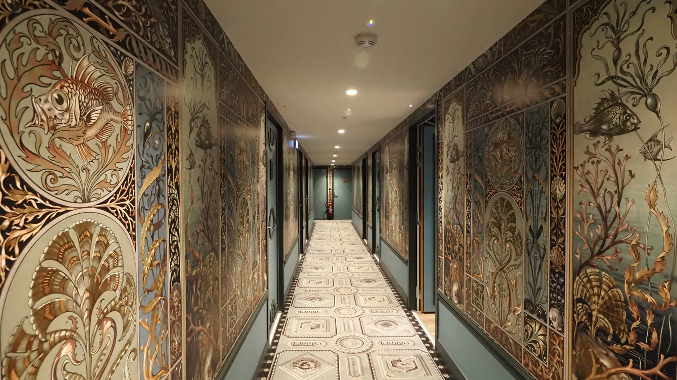Couloirs en trompe-l'œil de l'hôtel Le Magnifique, fresques marines, florales et façades à l'italienne, décor Vincent Darré