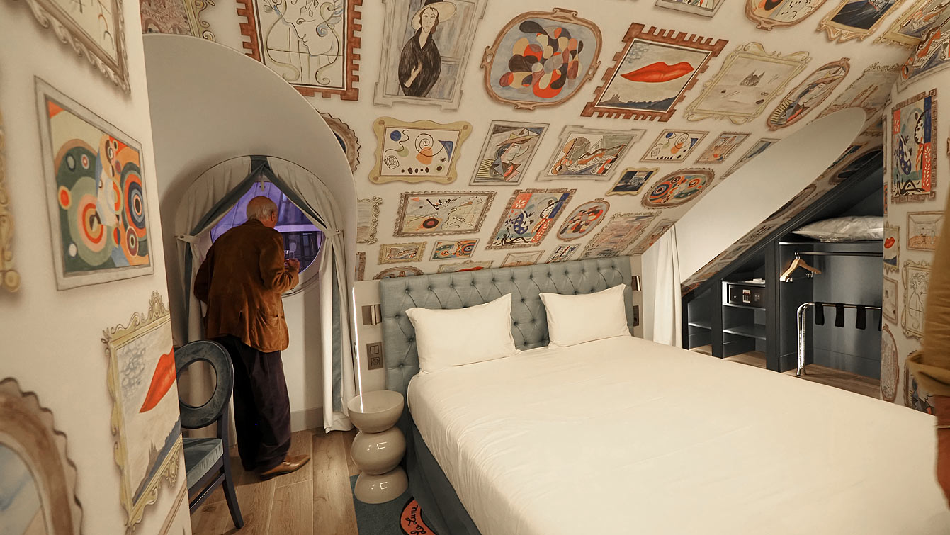 Chambre du cinquième étage de l'hôtel Le Magnifique, murs couverts de tableaux, et couloirs en trompe-l'œil