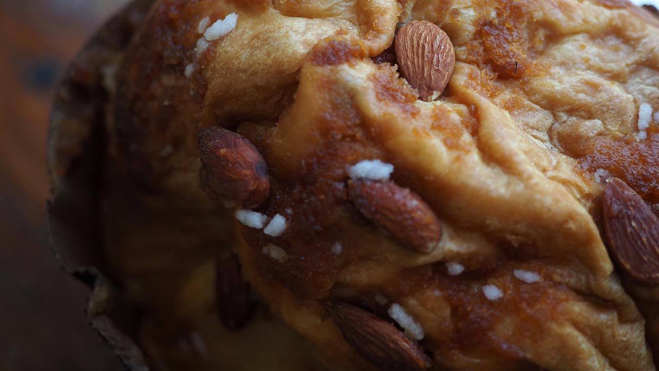 Dôme doré du panettone L'Effronté couvert d'amandes entières et de sucre en grains