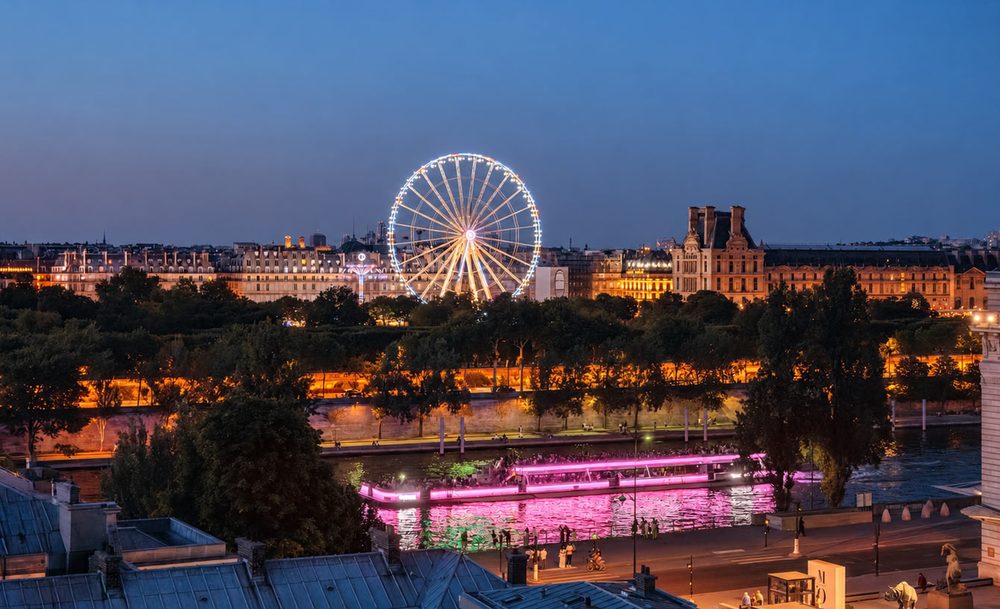 Bateau-Mouche illuminé en rose sur la Seine.