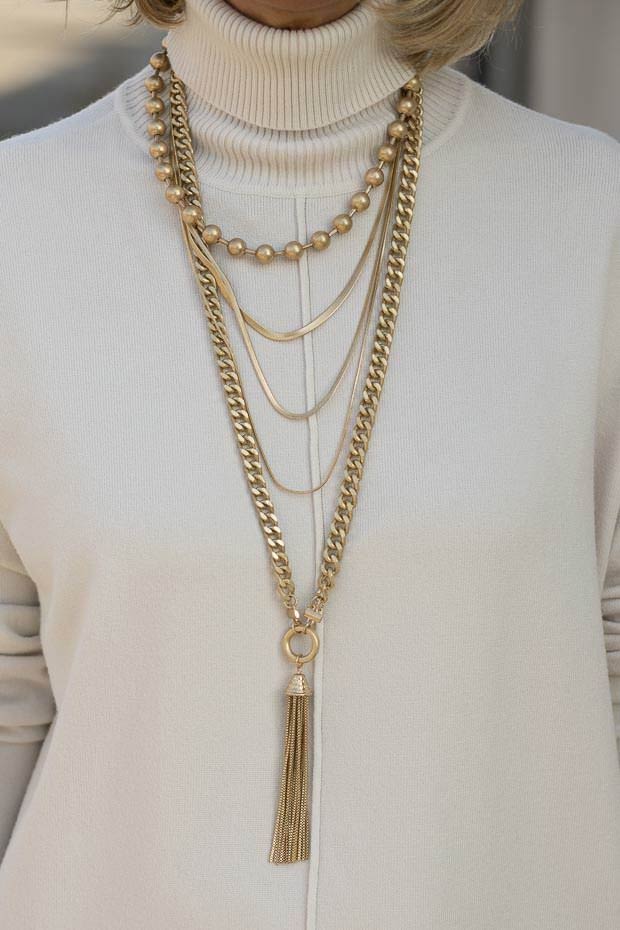 Sautoir multi-chaînes doré superposé sur pull en maille crème