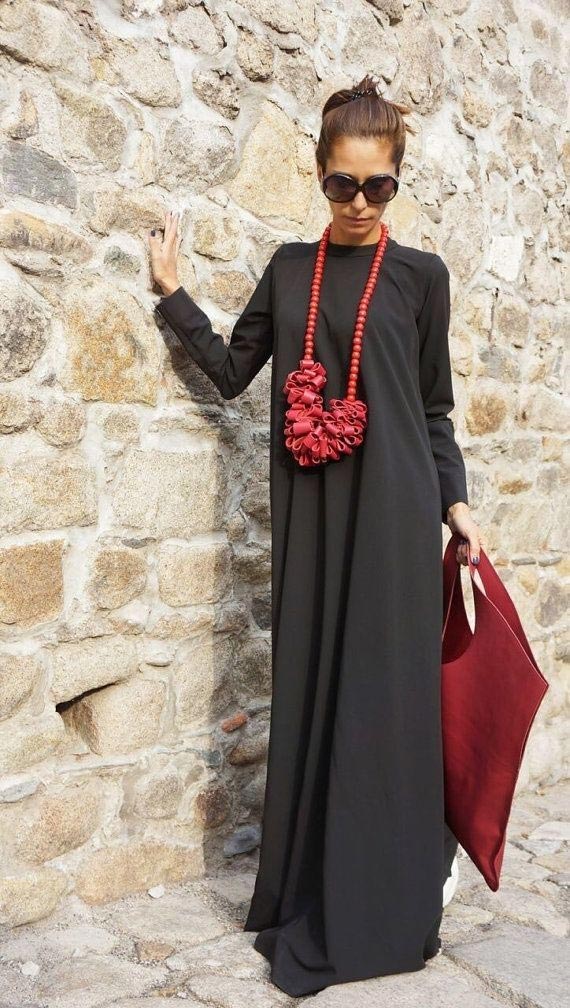 Sautoir rouge sculptural sur robe longue noire