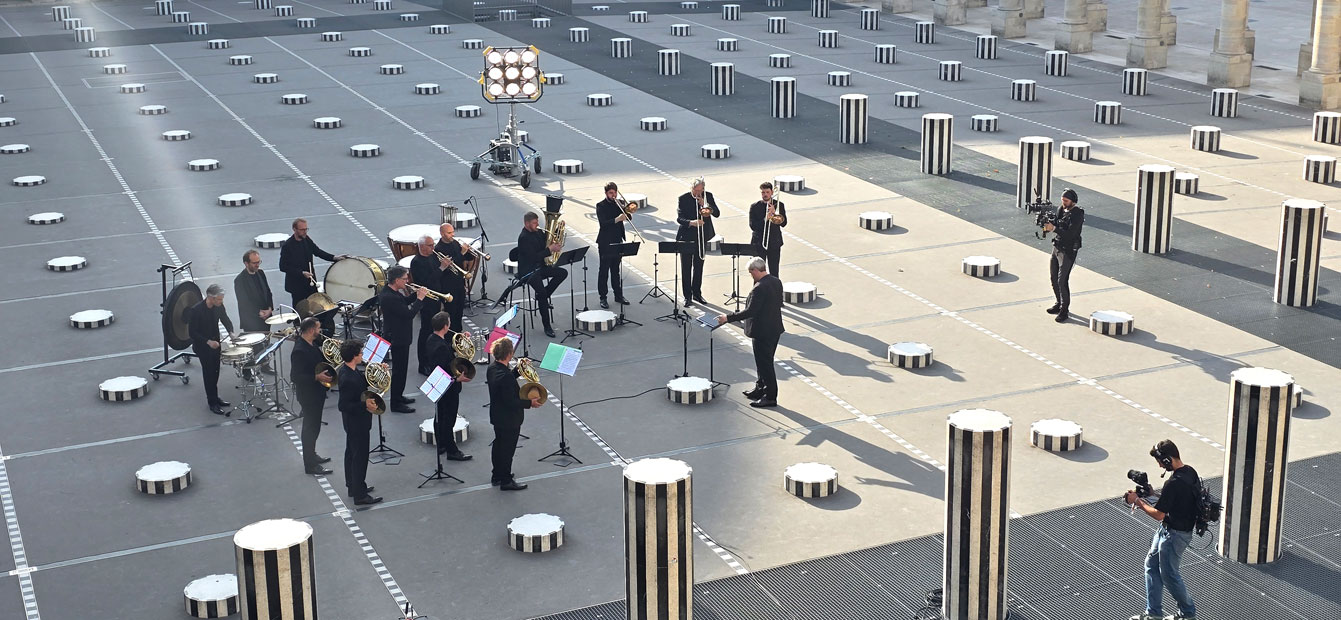  Au milieu de la célèbre installation de Daniel Buren et de ses colonnes, le grand Ensemble de cuivres et de percussions de l’Orchestre Philharmonique de Radio France ...